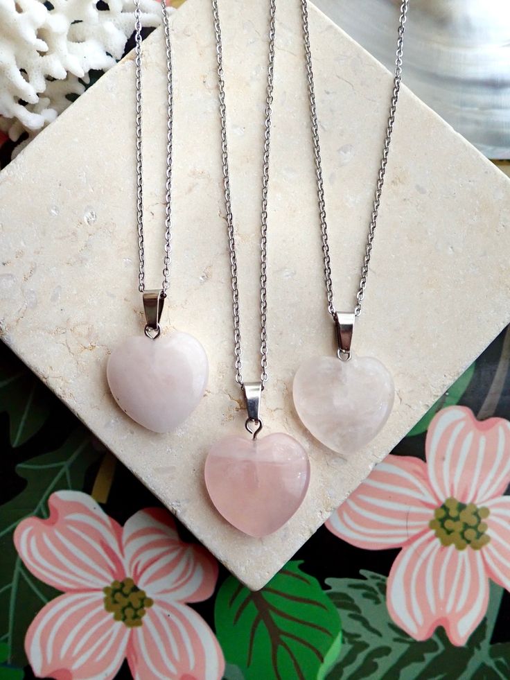 A genuine polished rose quartz heart - shaped crystal is strung on your choice of chain. This healing crystal makes a great gift for all those working on their heart chakra and is a sweet addition to anyones necklace arsenal. Metaphysical Properties:Rose quartz is known as a healing crystal and the stone of unconditional love. It's believed by some to emit strong vibrations of love, which are thought to: support emotional and relationship healing. inspire compassion. boost feelings of peace and Rose Quartz Crystal Necklace As Gift, Spiritual Crystal Necklace With Heart Beads As Gift, Spiritual Crystal Necklace With Heart Beads For Gifts, Spiritual Rose Quartz Necklace For Valentine's Day, Spiritual Pendant Crystal Necklace For Valentine's Day, Rose Quartz Heart Pendant Necklace With Charm, Heart-shaped Spiritual Crystal Necklaces For Healing, Spiritual Crystal Necklace With Heart Charm, Heart-shaped Crystal Necklace With Natural Stones For Healing