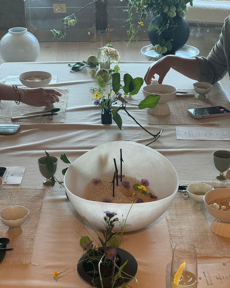 people sitting at a table with plates and bowls on it