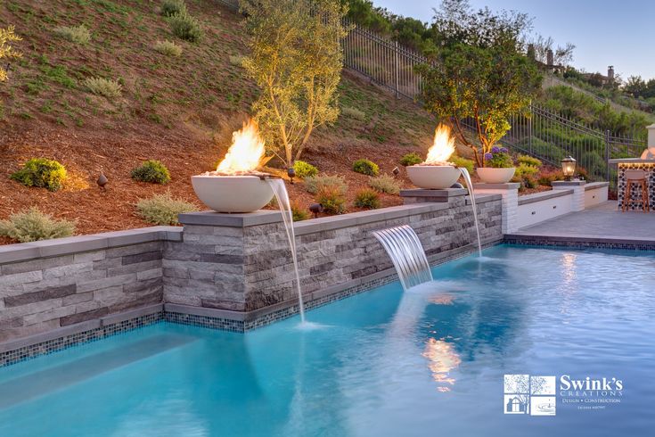 an outdoor pool with fire and water features