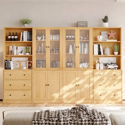 a living room filled with furniture and lots of books on top of wooden bookcases