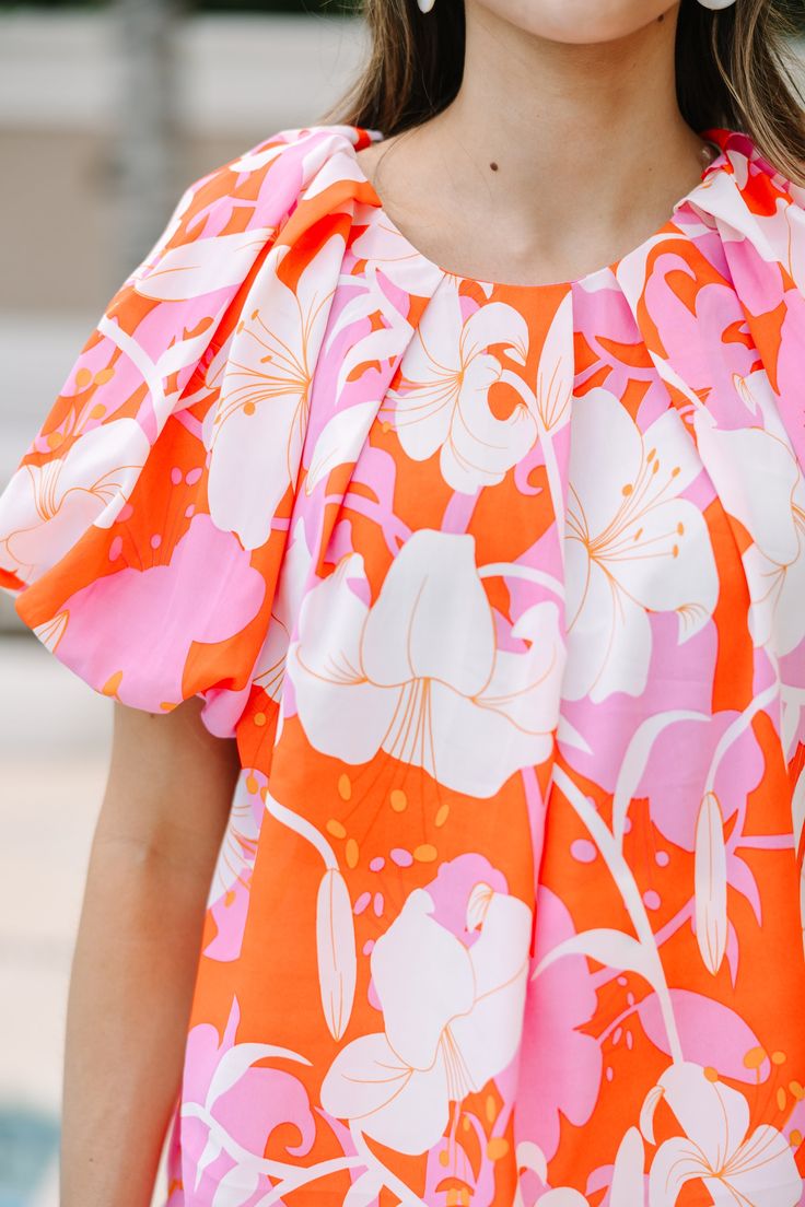 This blouse is all for you! It's going to look great for so many different occasions! That colorful print is stunning and we love that chic fit! Those puff sleeves really give this blouse such a flattering silhouette. Round neckline Button keyhole back Short bubble sleeves Bold floral print No stretch Savannah is wearing the small. Chic Summer Blouse With Abstract Print, Multicolor Printed Puff Sleeve Blouse, Summer Orange Tops With Bold Print, Spring Multicolor Puff Sleeve Blouse, Orange Bold Print Summer Top, Multicolor Puff Sleeve Blouse For Spring, Orange Tops With Bold Print For Summer, Feminine Printed Blouse For Day Out, Chic Orange Printed Top