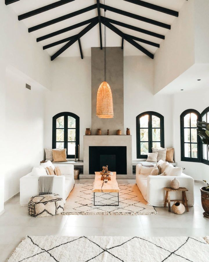 a living room filled with furniture and a fire place in the middle of an open floor plan