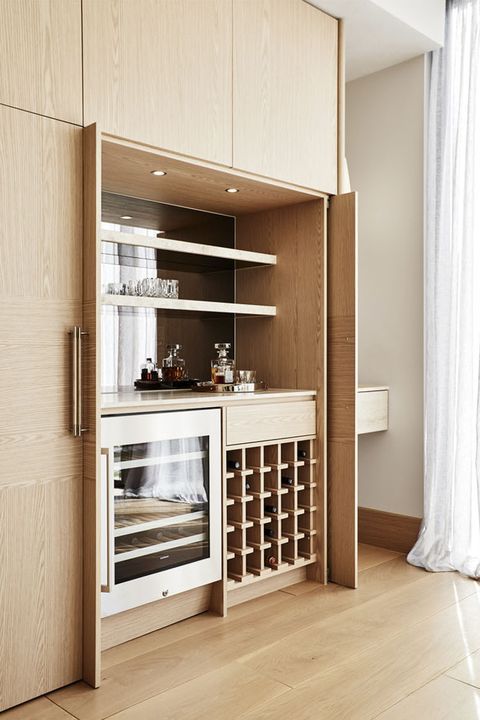 a wine rack in the middle of a kitchen with wooden cabinets and drawers on both sides