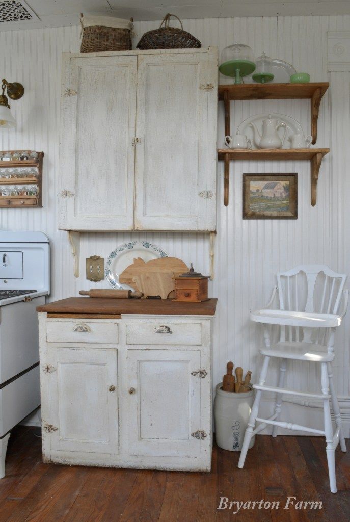 an old fashioned kitchen with white appliances and wood flooring