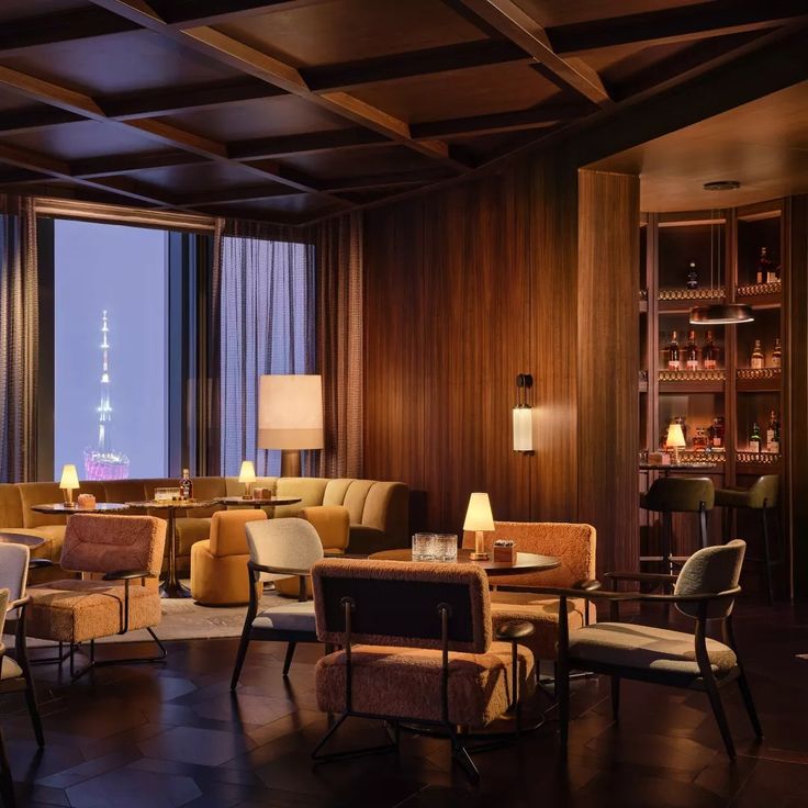 a living room filled with lots of furniture next to a tall window covered in curtains