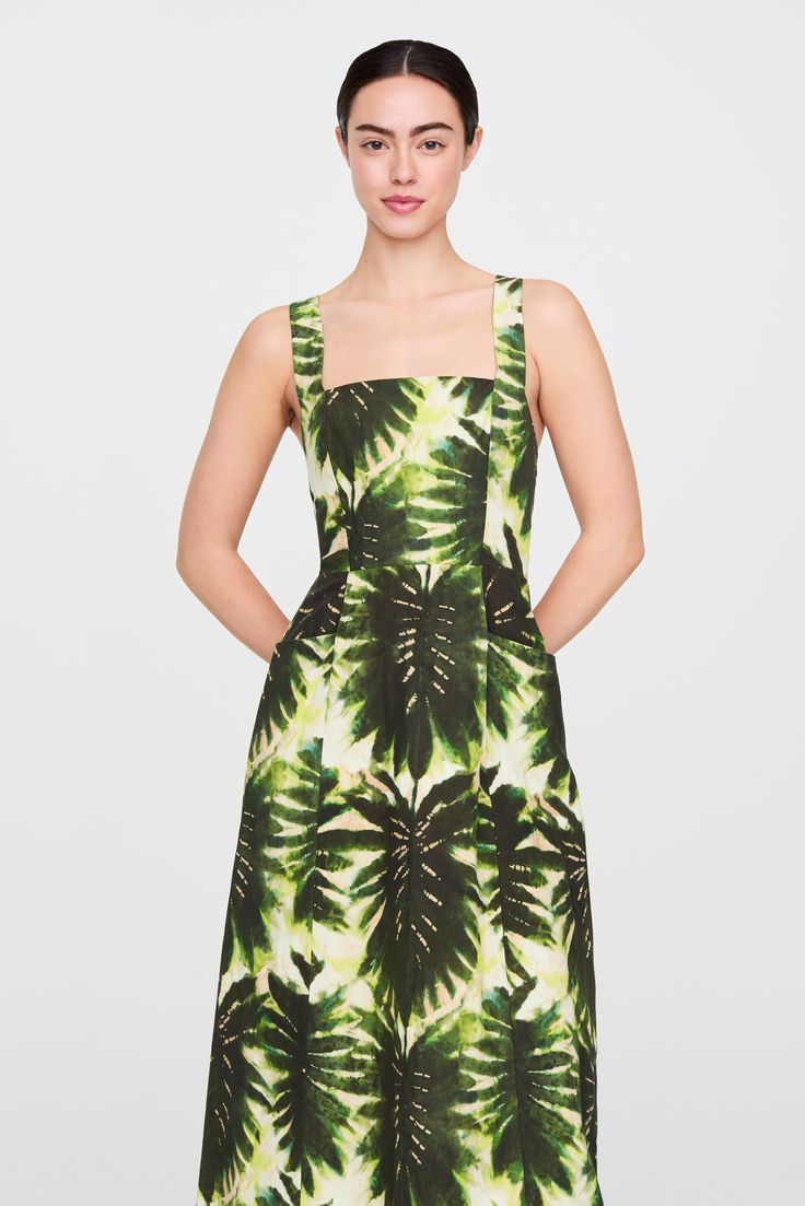 Our new Hella dress, which comes in our leafy Lupin print (a deep army green botanical with pops of peach and teal), is as pretty from the front as it is from the back, where military-style grommets and lace-up canvas ties add high-low appeal to the well-cut sundress. -Tie back bodice with invisible zipper in skirt-Apron front pockets-29% silk / 29% cotton / 42% linen-Unlined-Care instructions: machine wash on gentle cycle and hang to dry Green Printed Midi Dress For Garden Party, Garden Party Green Printed Midi Dress, Green A-line Midi Dress With Floral Print, Green Tropical Print Summer Midi Dress, Green Printed Knee-length Dress, Green Tropical Print Midi Dress For Garden Party, Spring Green Tropical Print Midi Dress, Green Summer Dress With Plant Print, Fitted Leaf Print Summer Dress