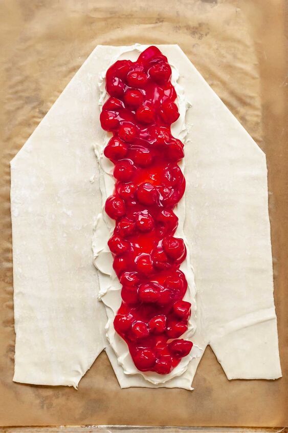 a piece of paper with red fruit on it and some white wax in the middle