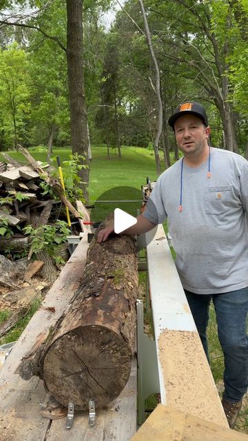 a man standing next to a large log