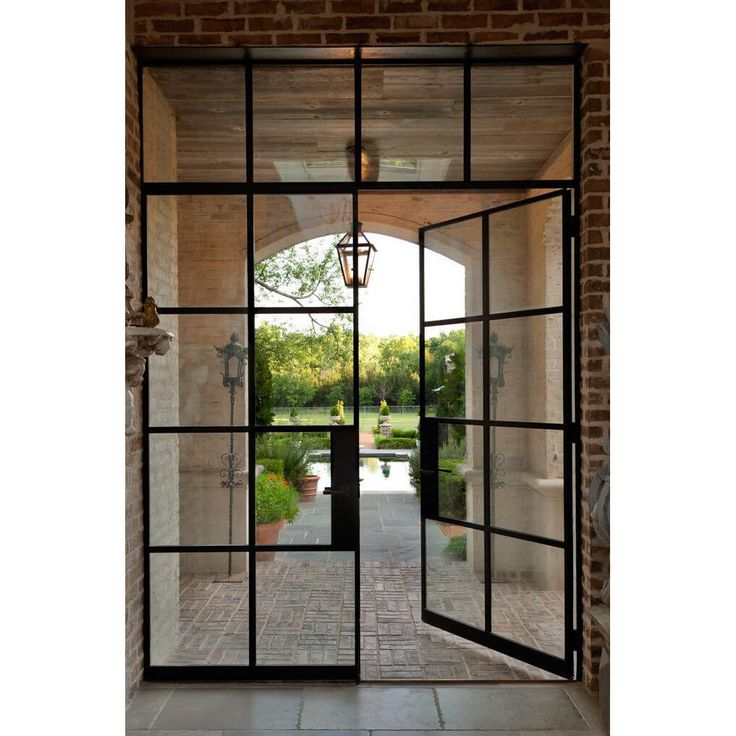 an open glass door leading into a garden