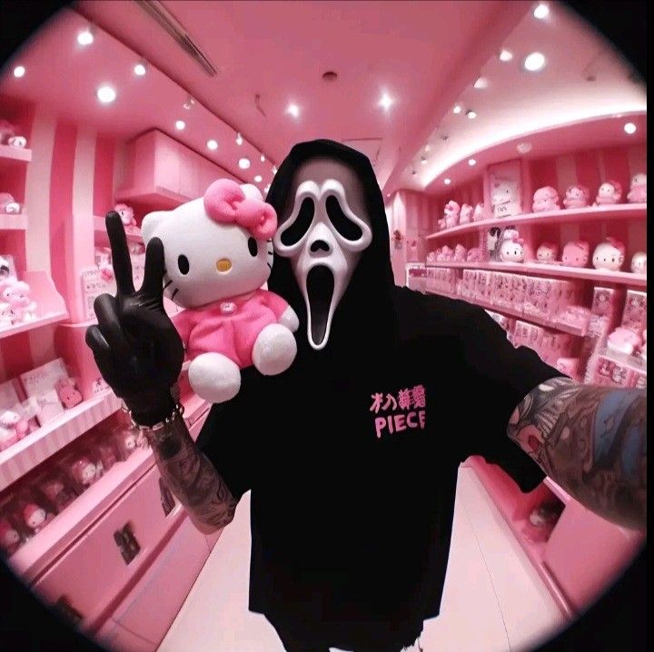 a person wearing a hello kitty mask and holding up a stuffed animal in a store