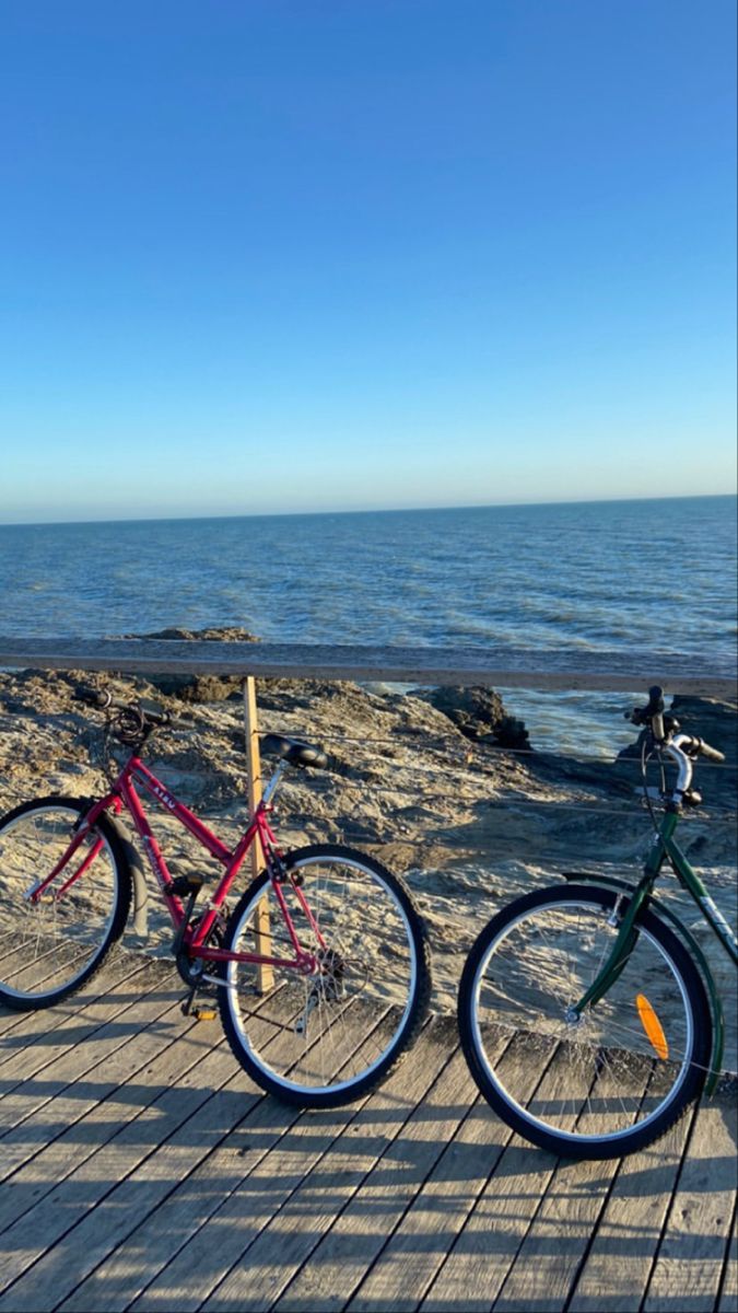 two bikes parked on a wooden pier near the ocean