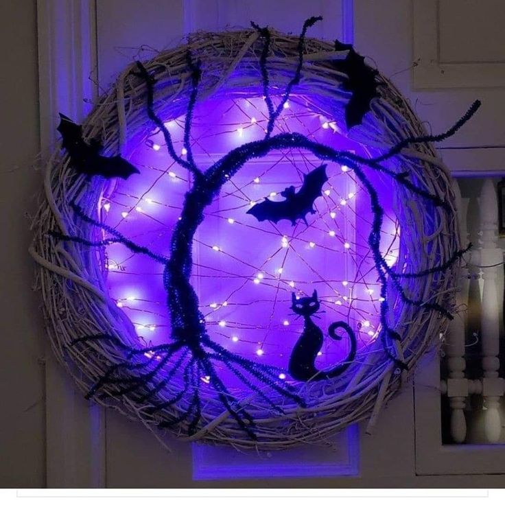 a wicker wreath decorated with halloween lights and bats