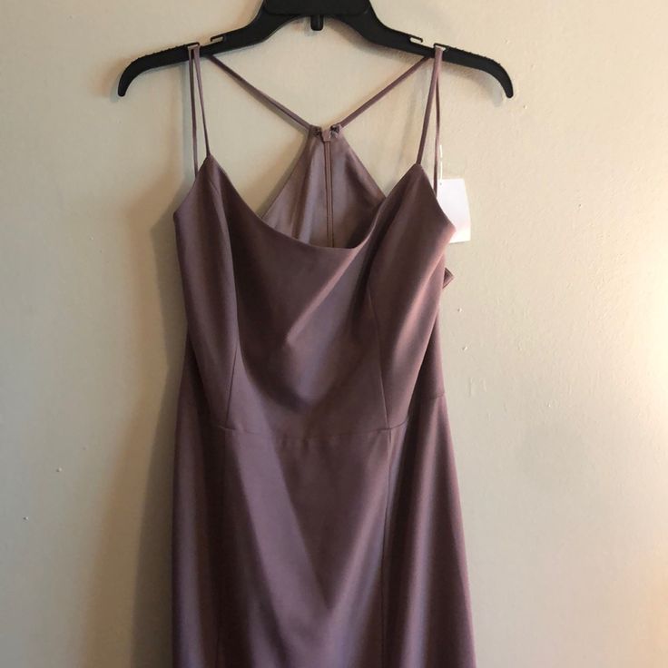 a dress hanging on a hanger against a wall