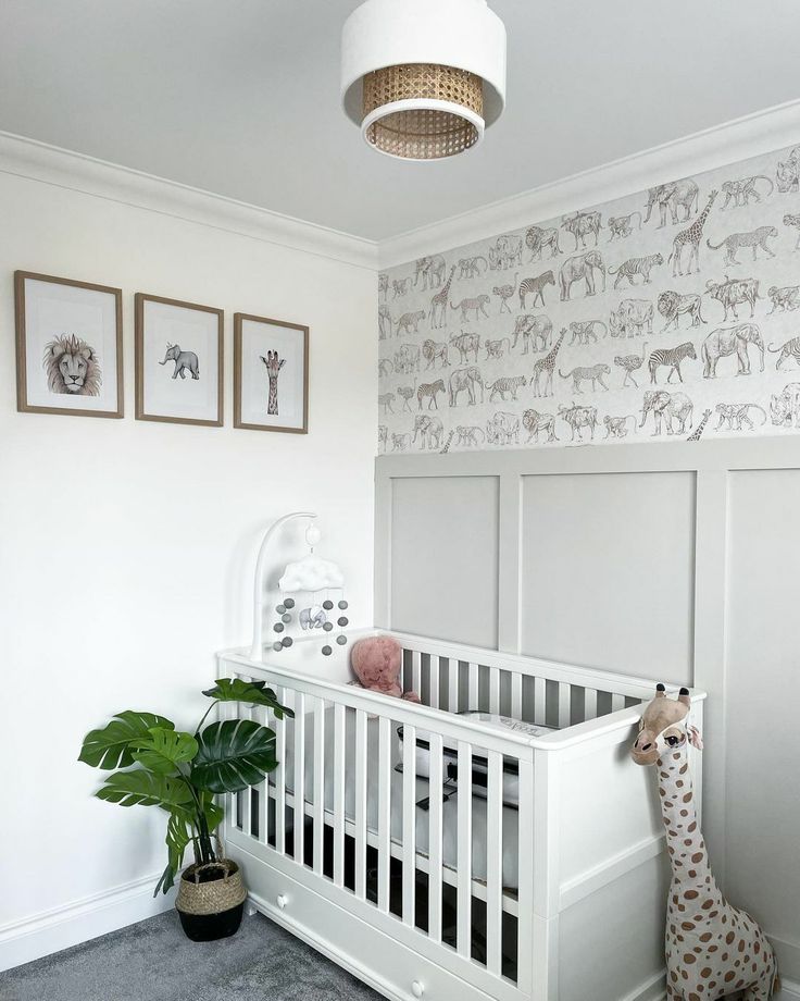 a baby's room with a white crib and wallpaper on the walls