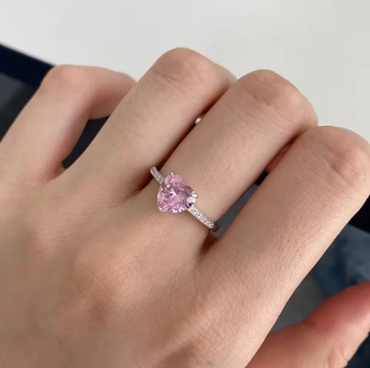 a woman's hand with a pink diamond ring