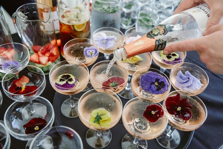 a person pours wine into glasses with flowers on them