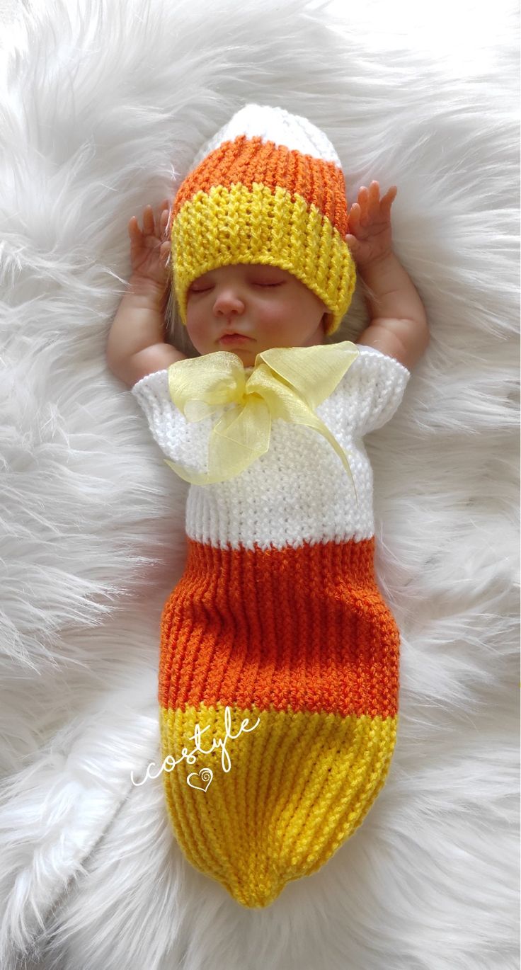 a baby wearing a knitted hat and diaper is laying on a fluffy white blanket