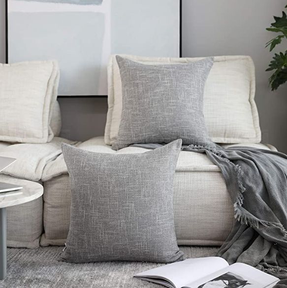 a living room with couches and pillows on the floor