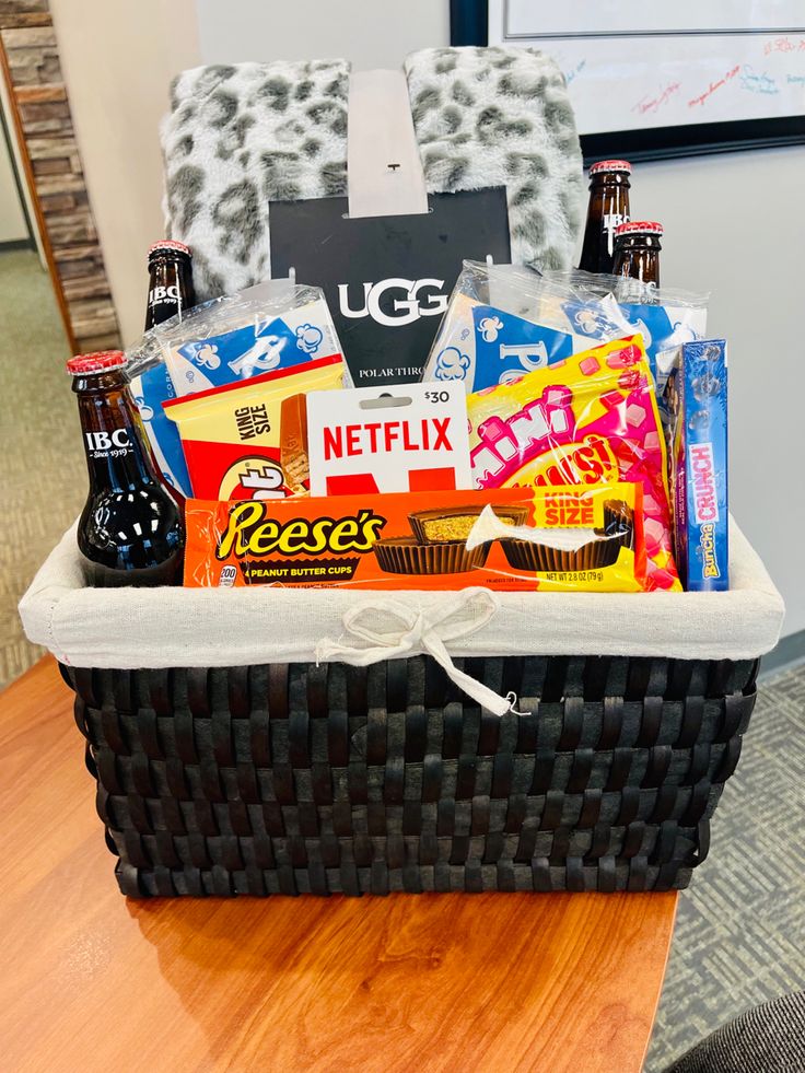 a basket filled with snacks and drinks on top of a wooden table