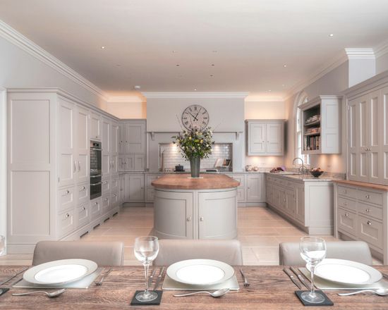 an image of a kitchen setting with white cabinets and marble counter tops, along with plates on the dining room table