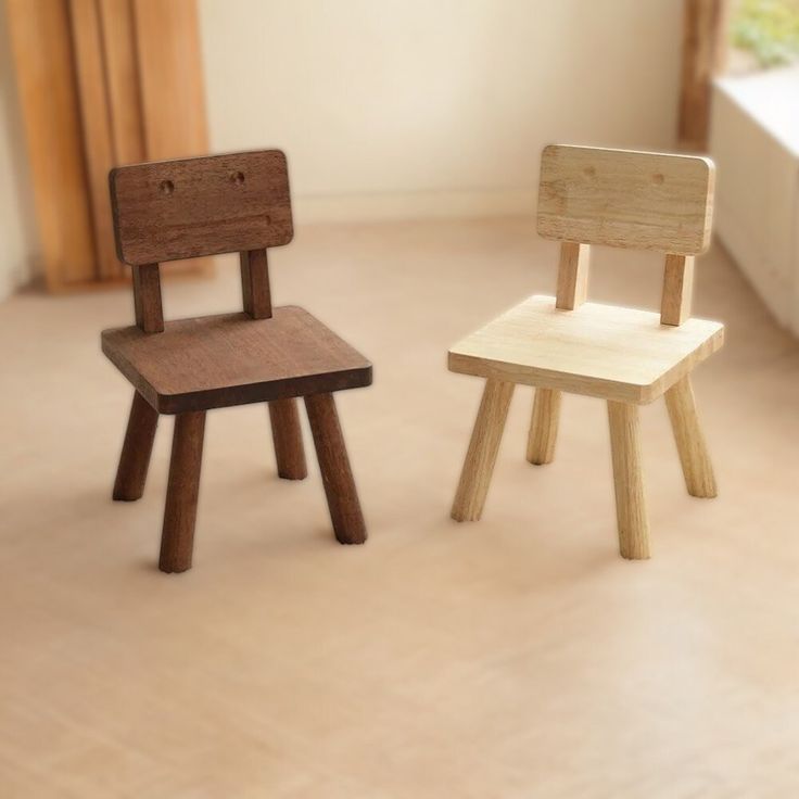 two wooden chairs sitting next to each other in a room