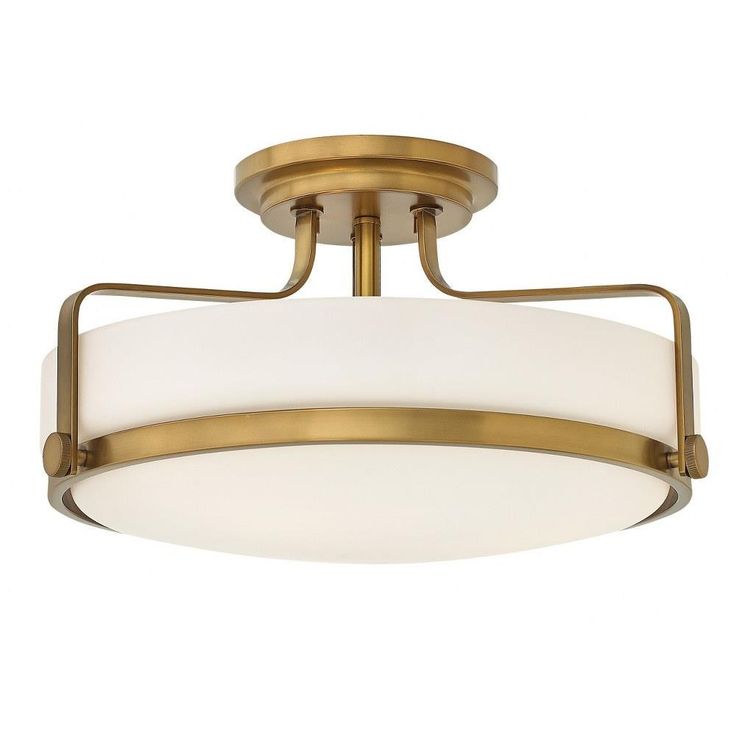 a semi flush light fixture with white glass shades on the bottom and gold trimmings