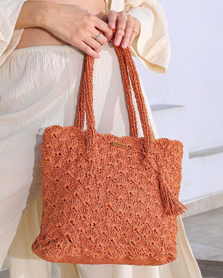 a woman carrying an orange crocheted purse