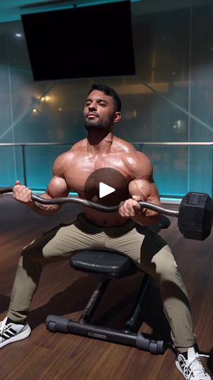 a man squats on a bench while holding a barbell