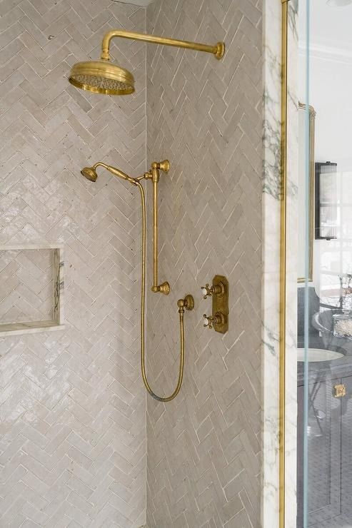 a bathroom with a shower head and hand held shower faucet