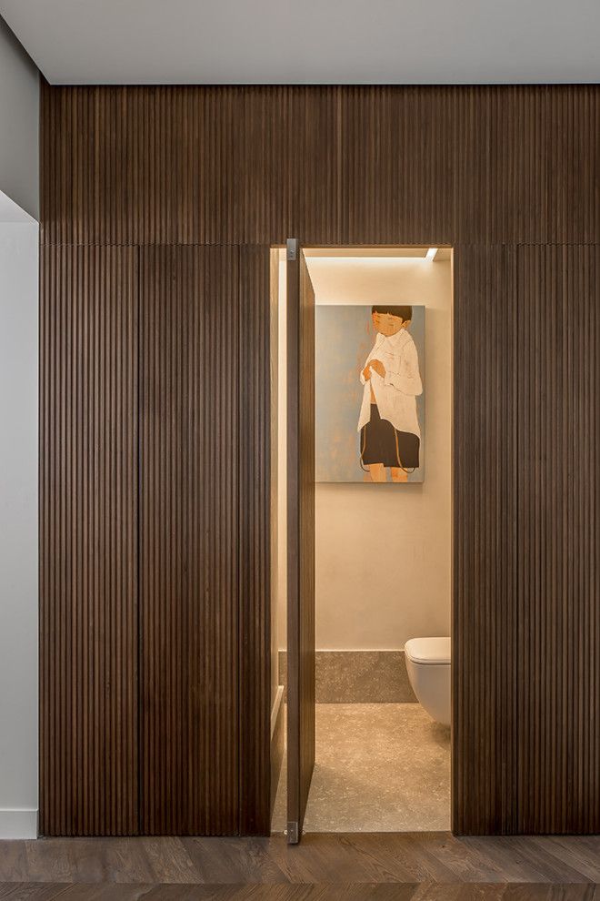 an open door leading to a bathroom with a painting on the wall and wooden flooring