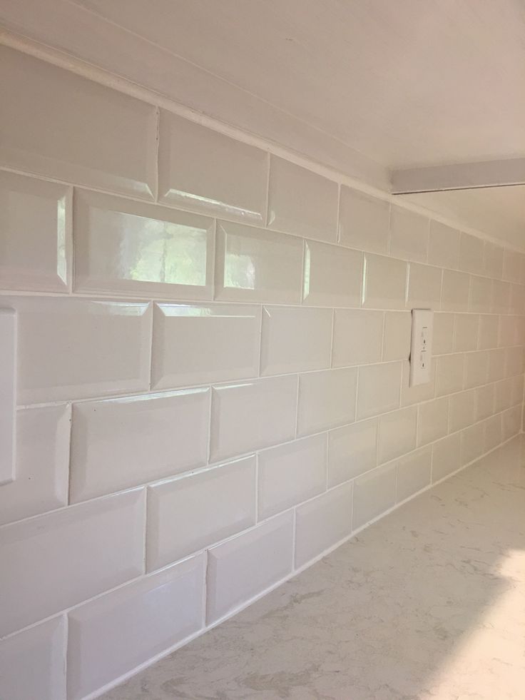 a kitchen with white tile and no one in the room or someone standing near it