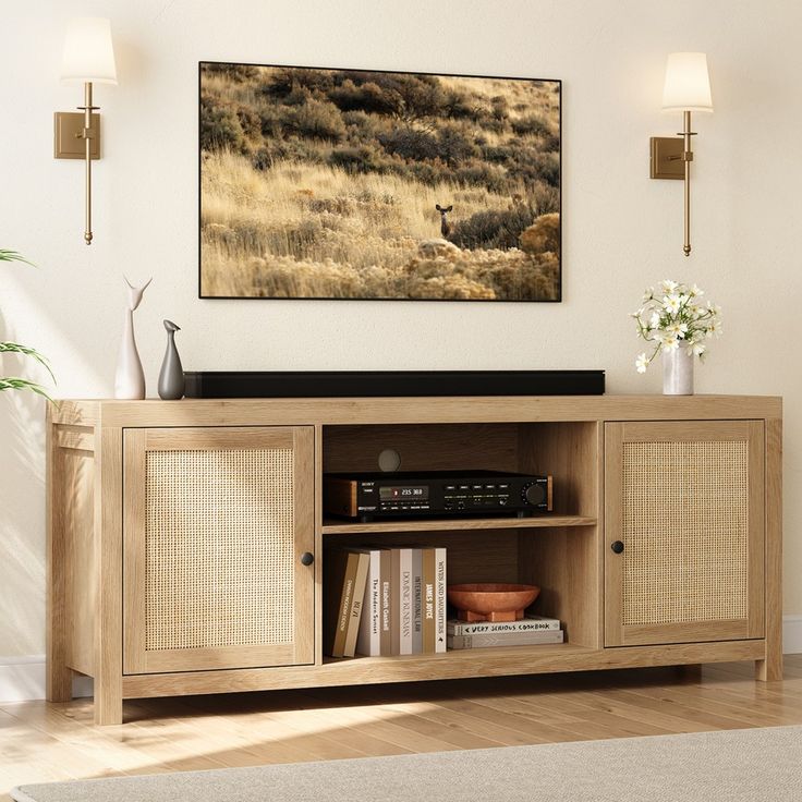 a living room with a large television on top of a wooden entertainment center next to a wall mounted painting