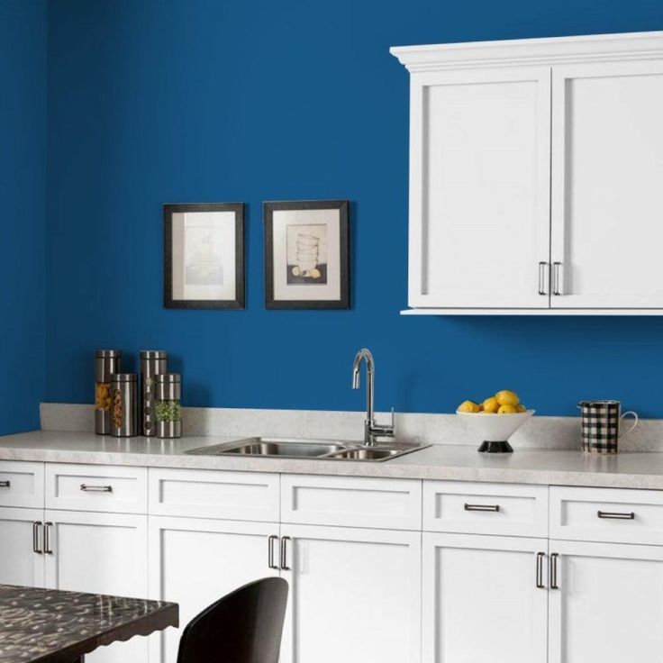 a kitchen with blue walls and white cabinets