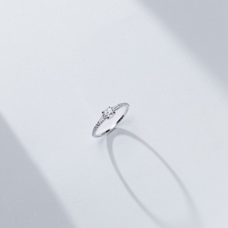 The center rose cut diamond that sits between two tapered baguettes evokes an art-deco vibe. The low profile nature of the rose cut allowed us to make an engagement ring where the diamonds all flowed into each other while hugging the finger for ultimate wearability. 14K sustainable gold Center: 0.25ct natural rose cut diamond 0.22 tcw of tapered baguette and round natural diamonds All diamonds are GH color/VS clarity Dimensions: Band Width 2.0mm taperingDelivery: This item is made to order. Plea Promise Ring With Rose Cut Baguette Diamonds, Timeless Solitaire Diamond Ring For Proposal, Timeless Lab-grown Diamond Ring With Rose Cut Diamonds, Delicate White Gold Diamond Ring With Single Cut Diamonds, Fine Jewelry Diamond Ring With Baguette Cut For Promise, Fine Jewelry Baguette Cut Diamond Promise Ring, Timeless Asscher Cut Diamond Ring For Proposal, Fine Jewelry Diamond Ring For Proposal With Baguette Cut, Promise Diamond Ring With Baguette Single Cut