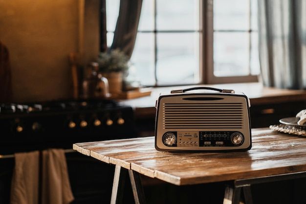 an old fashioned radio sitting on top of a wooden table in front of a window