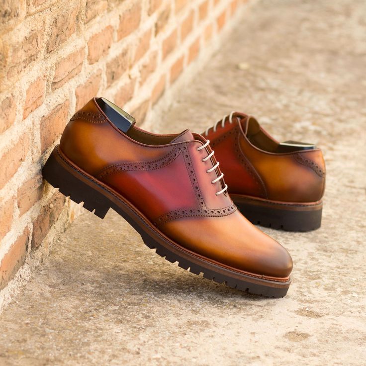 Stride into style with our Lincoln Ave. Saddle Shoe No. 8039! 🕺 Featuring a base of exquisite cognac painted calf, accented by bold reds on the saddle and tongue. 💫 Light burnishing, taupe rounded laces, and plush tan calf leather lining marry comfort with elegance. Complete with an ultra-light commando rubber sole and the durable Goodyear welt, these handcrafted wonders are your ticket to timelessly chic adventures. #ShoeGoals #ArtisanFootwear #SaddleShoeStyle 🌟 Brown Oxfords With Red Sole For Formal Occasions, Luxury Brown Dress Shoes With Red Sole, Brown Luxury Dress Shoes With Red Sole, Designer Brown Goodyear Welted Dress Shoes, Designer Brown Dress Shoes With Goodyear Welt, Classic Red Leather Shoes For Fall, Fall Red Leather Oxfords, Red Almond Toe Oxfords For Semi-formal Occasions, Brown Bridle Leather Shoes For Derby