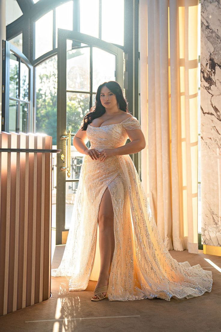 the woman is posing in her wedding dress and high heels for the photo shoot by the window