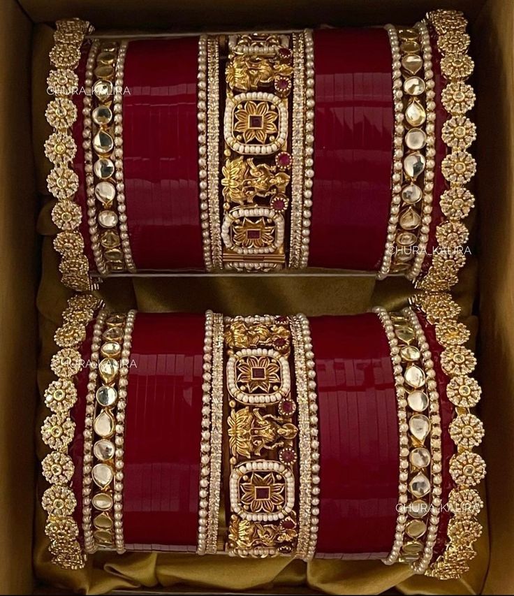 two red and gold bangles in a box with golden trimmings on them