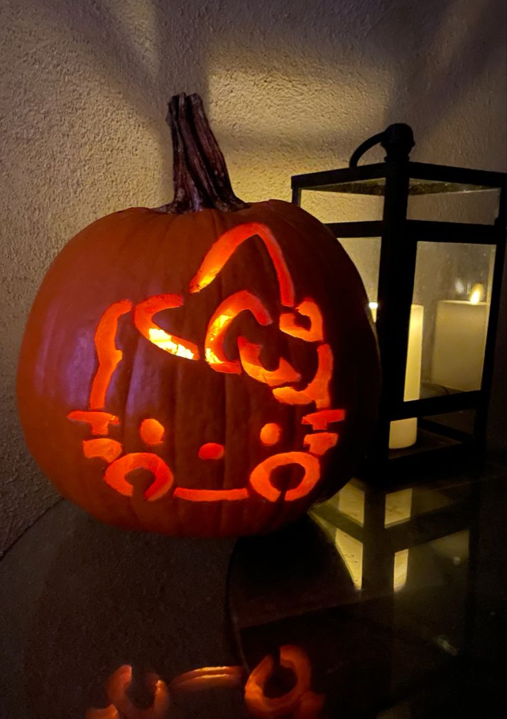 a pumpkin carved to look like a cat with the word hello kitty written on it