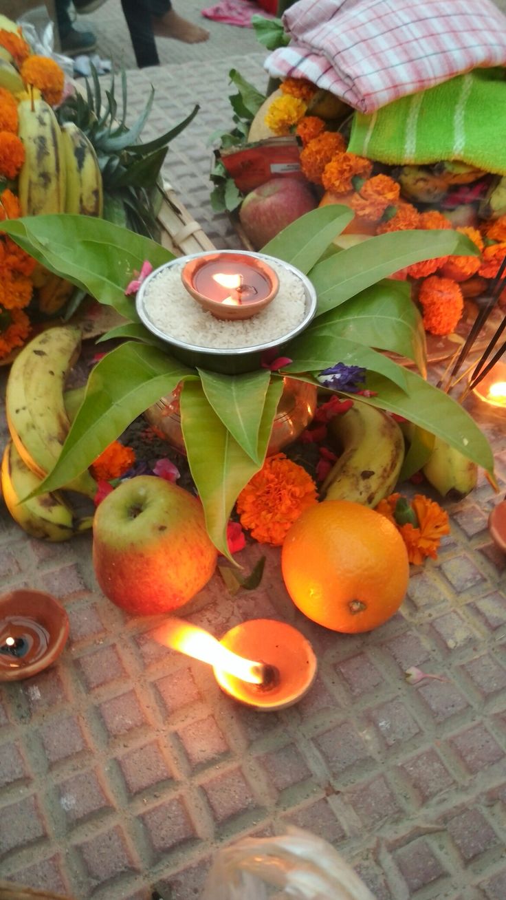 an arrangement of fruit and candles on the ground