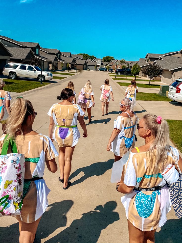 several girls in bathing suits walking down the street