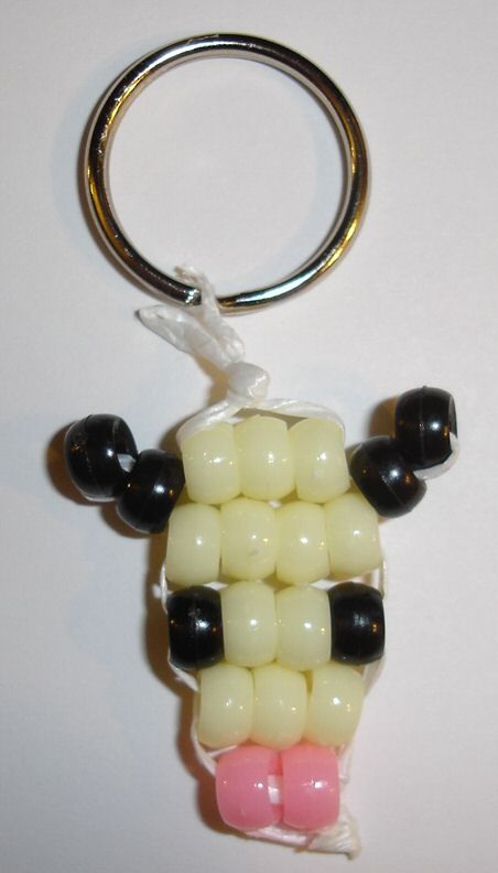 a keychain made to look like a sheep with black, white and pink beads