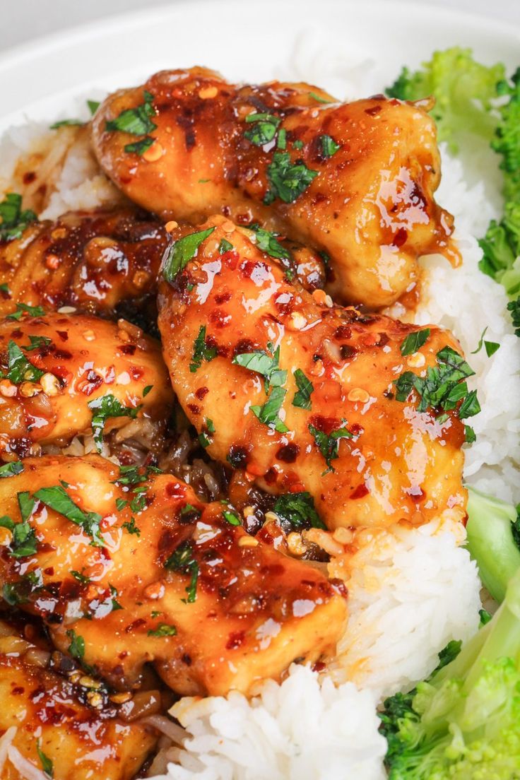 chicken and broccoli are served on rice in a white bowl with garnish