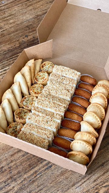 a box filled with lots of different types of doughnuts on top of a wooden table