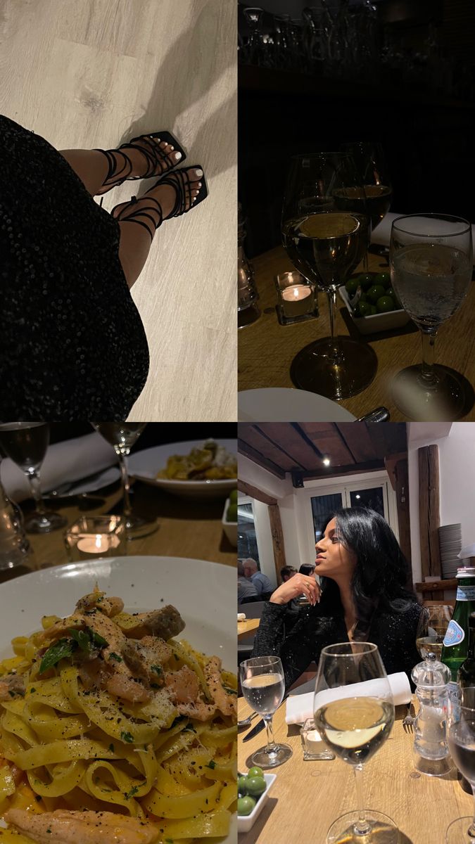 a woman sitting at a table in front of plates of food and glasses of wine