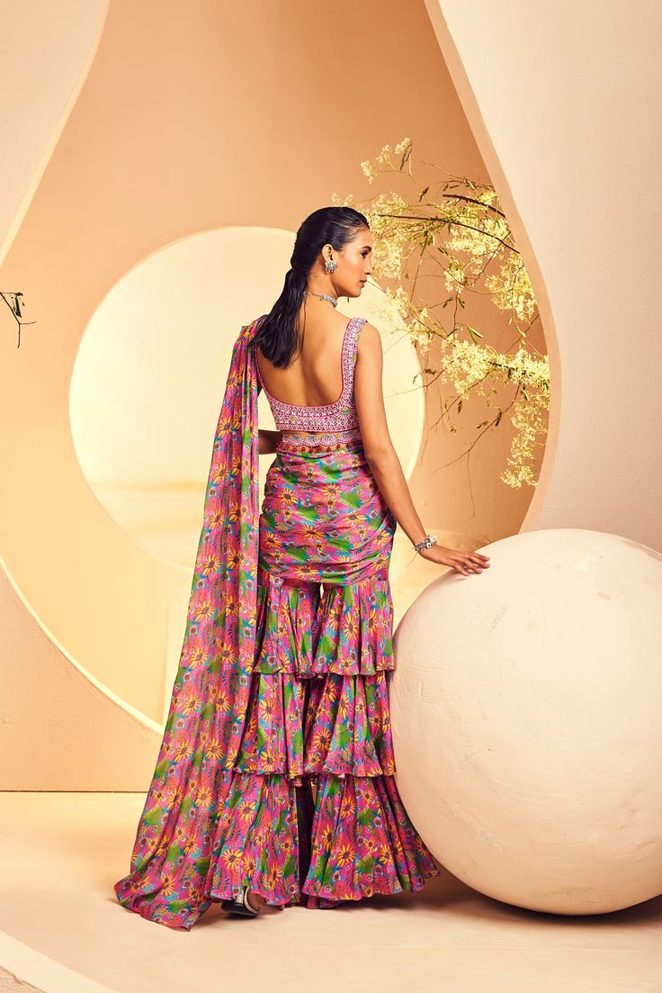 Featuring a fun layered sharara sari in a modern abstract floral print. The blouse is fully hand embroidered with intricate Japanese beads and cutdana embroidery. The belt is accentuated with colored headstones.From Aneesh Agarwaal's Naksh collection. DELIVERY TIMEPlease allow 8-12 weeks for your outfit to arrive. FABRIC DETAILSChinon Chiffon Professional cleaning only. Bollywood Style Silk Sharara With Floral Print, Multicolor Floral Print Palazzo Set For Weddings, Wedding Palazzo Set With Floral Print, Wedding Floral Print Multicolor Palazzo Set, Wedding Multicolor Floral Print Palazzo Set, Wedding Multicolor Palazzo Set With Motifs, Fusion Silk Set With Traditional Drape, Silk Floral Print Sharara For Party, Silk Fusion Set With Traditional Drape