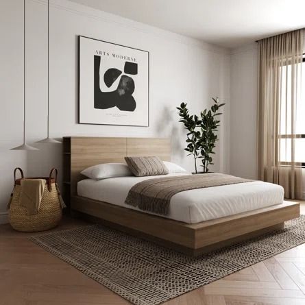 a bedroom with a bed, rugs and pictures on the wall above it in front of a window