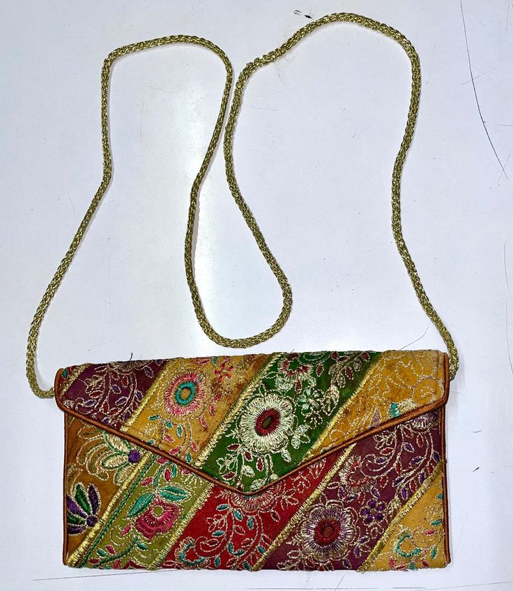 This is a New Handmade Purse/clutch in Vintage Style. It is made by vintage fabrics. It is multi-color purse. It is Beautifully decorated with vintage fabric, Sequins, Mirror and thread embroidery work along with nice print. It is containing a magnetic button enclosure and a tread chain string for easy carrying. It is contained two zipper pockets inside the bag. You can use this purse for marriage, Parties and Gifting purpose. The image may show slight differences to the actual bag in color, shape and texture. Bag Sizing (in Inches) approx. Length: "30approx. Width:   17"approx. The color may slightly differ due to different computer color setting. Shipping Policy: - We ship worldwide from India.  We ship parcels through Standard Shipping Service of India Post which provides proper trackin Traditional Multicolor Embroidered Clutch For Evening, Multicolor Rectangular Evening Bag For Festivals, Traditional Multicolor Embroidery Clutch For Evening, Elegant Multicolor Embroidered Shoulder Bag, Embroidered Rectangular Shoulder Bag For Celebration, Rectangular Embroidered Shoulder Bag For Celebration, Elegant Multicolor Shoulder Bag For Festive Occasions, Elegant Multicolor Festive Shoulder Bag, Multicolor Embroidered Rectangular Clutch For Festivals