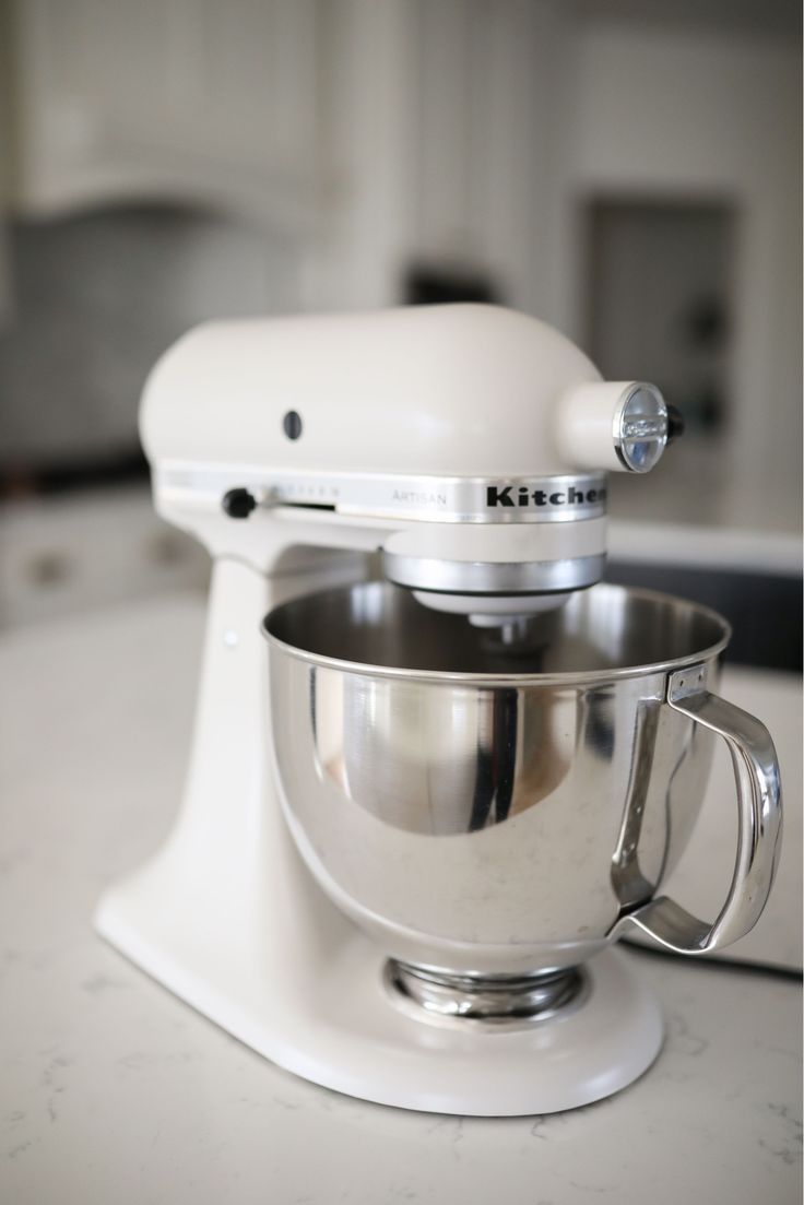 a white kitchen mixer sitting on top of a counter