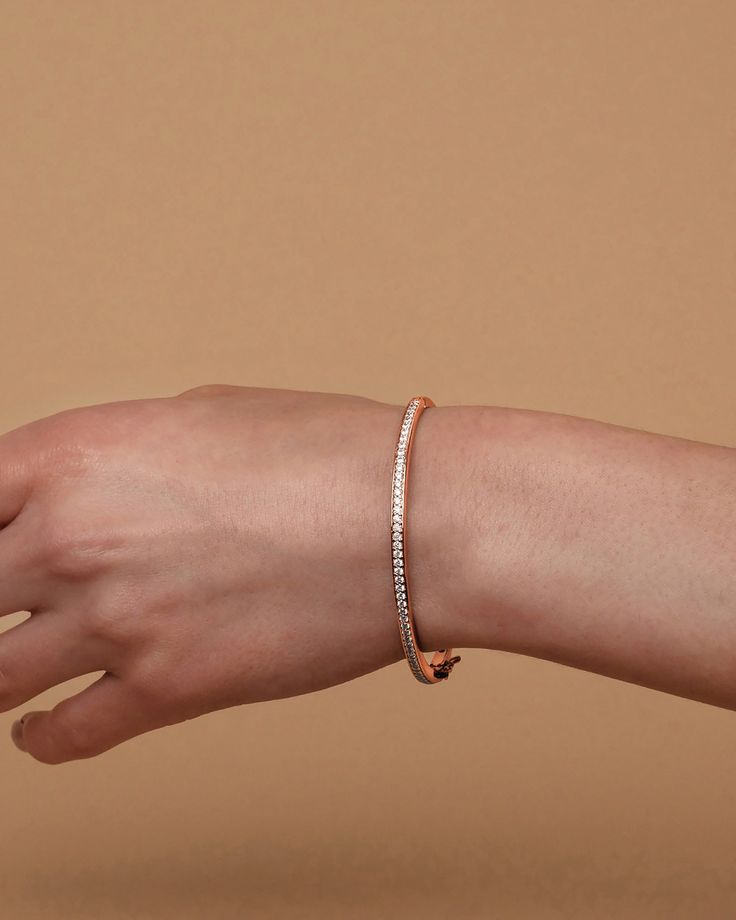 Our Lana Bangle is an essential piece of arm candy that you absolutely need in your jewelry box. Sleek and minimal with the subtle glimmer of the cubic zirconia, this bracelet can accompany you to any event or occasion.Materials 14K yellow gold, rose gold or white gold plated AAAAA Cubic Zirconia Measurements: Width: 64.5mm (2.54”); Height: 57.5mm (2.26”); Thickness: 3.3mm (.13”) Hypoallergenic; nickel, lead, and cadmium free Dainty Rose Gold Bracelets For Everyday Luxury, Dainty Rose Gold Everyday Luxury Bracelets, Everyday Luxury Rose Gold Cubic Zirconia Tennis Bracelet, Adjustable Rose Gold Diamond Bracelet For Everyday, Fine Jewelry Everyday Rose Gold Diamond Bracelet, Rose Gold Bracelets For Everyday Luxury, Minimalist Rose Gold Jubilee Bracelet, Adjustable Rose Gold Diamond Bangle, Rose Gold Dainty Diamond Bracelet For Everyday Luxury